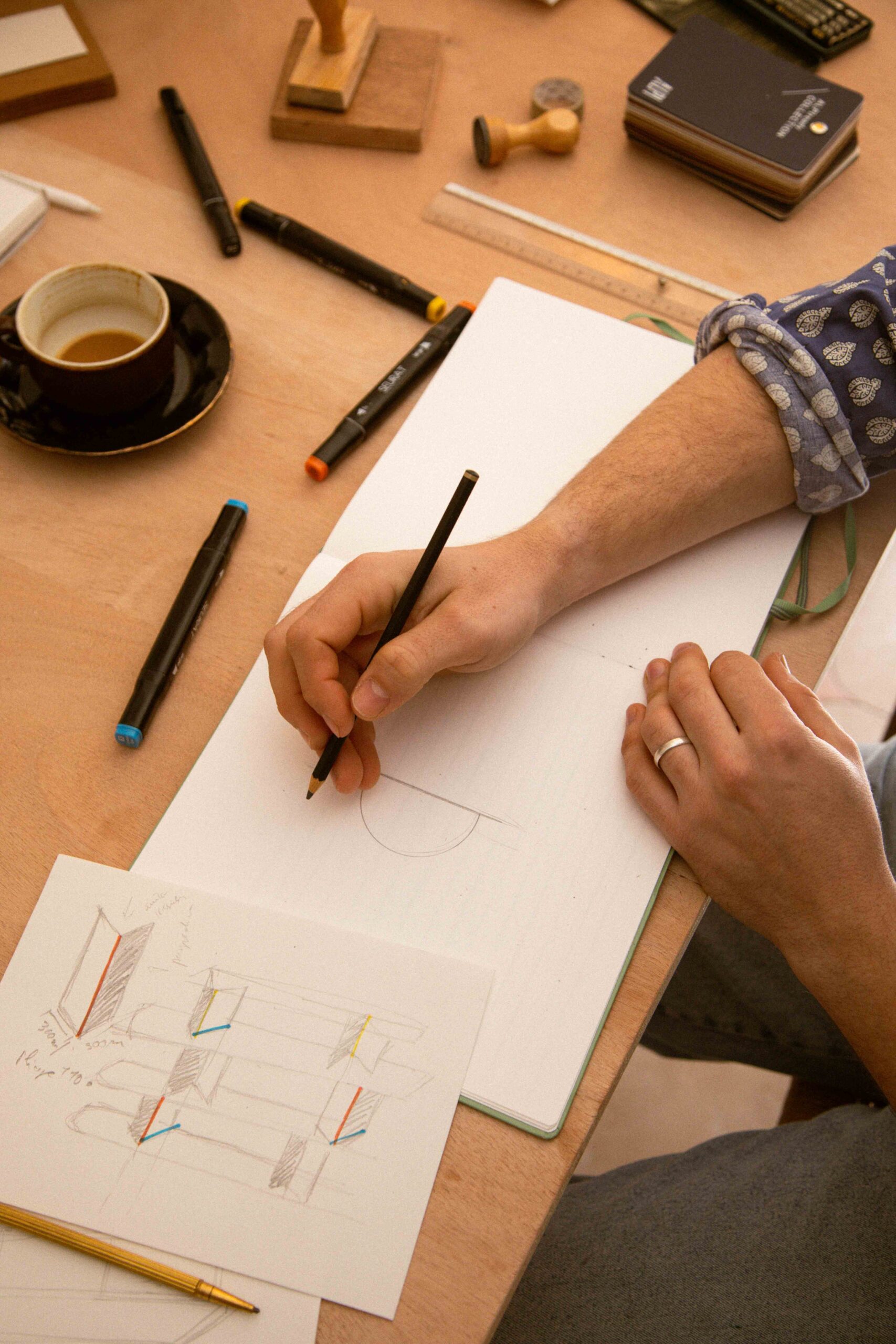 Photo de mains qui dessinent un croquis.